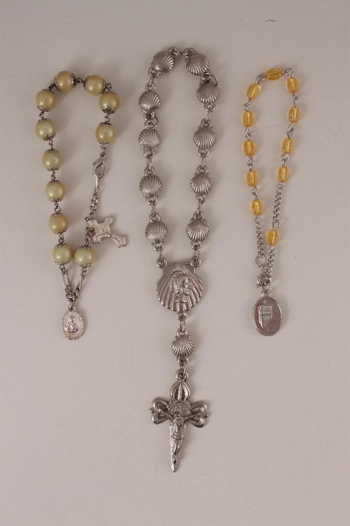 Rosary Bracelets (3): One irridecent yellow beaded bracelet with crucifix, one yellow glass beaded bracelet and one silver tone shell shaped beaded crucifix keepsake/bracelet.