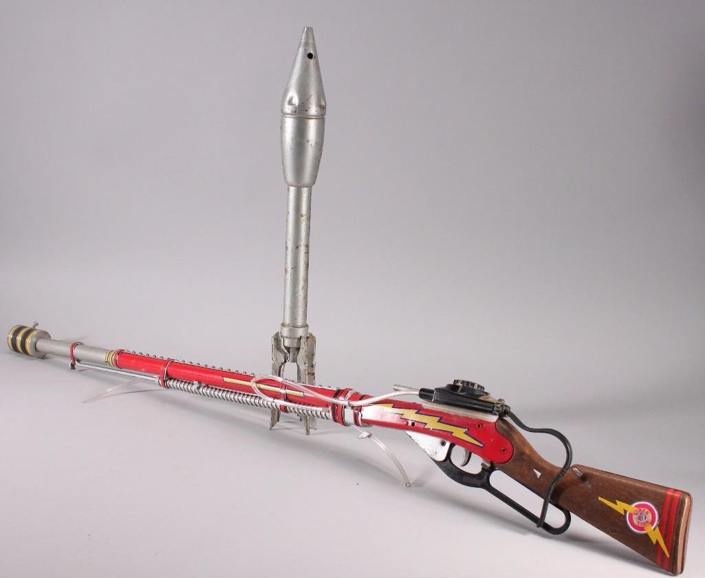 Novelty Stan Lemkuil TOY Gun & DUMMY BAZOOKA ROUND (2): Hand crafted NOVELTY Stan Lemkuil TOY gun that measures 45" long (handle needs repair) and DUMMY BAZOOKA ROUND measures 21.5" (shows age).