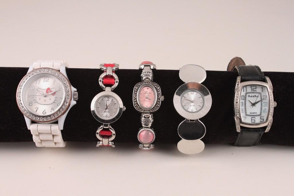 Ladies Wrist Watches (5): One Peck & Peck Quartz watch with rhinestones surrounding face and black leather band (one rhinestone missing, band shows wear); three Quartz watches with silver tone linked bands and one Hello Kitty