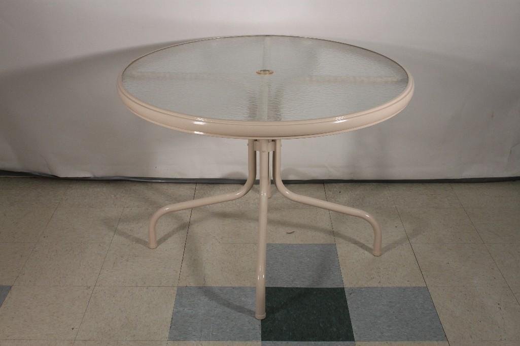 Glass Top Patio Table: Outdoor table measures 41" wide x 29" tall, metal base with glass top, in new condition, has hole for umbrella.