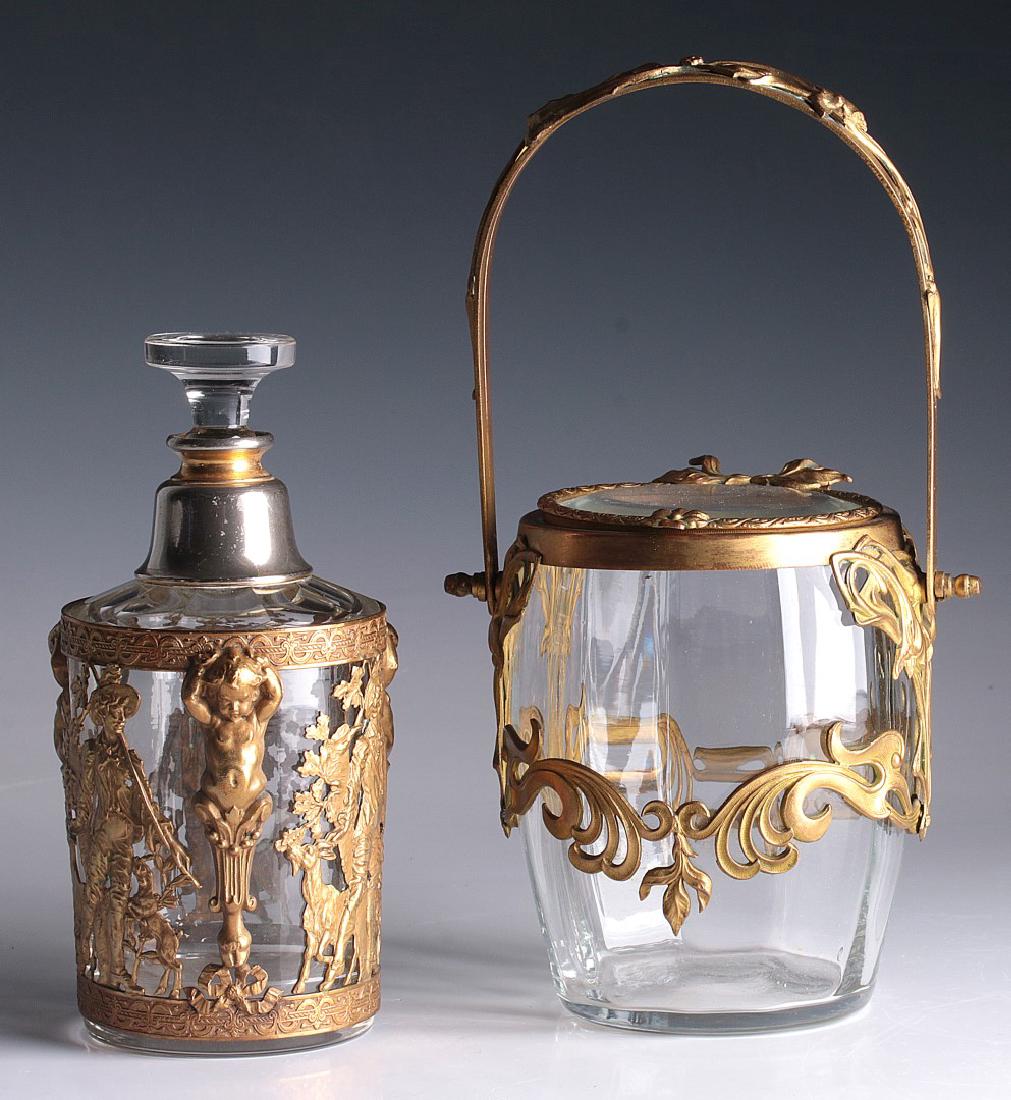 EARLY 20TH C. FRENCH ORMOLU MOUNTED VANITY PIECES: A clear glass cylindrical bodied bottle with an elaborately decorated gilt overlay of putti caryatid pilasters terminating in a hoofed foot dividing pastoral scenes of a shepherd flanked by goats amon