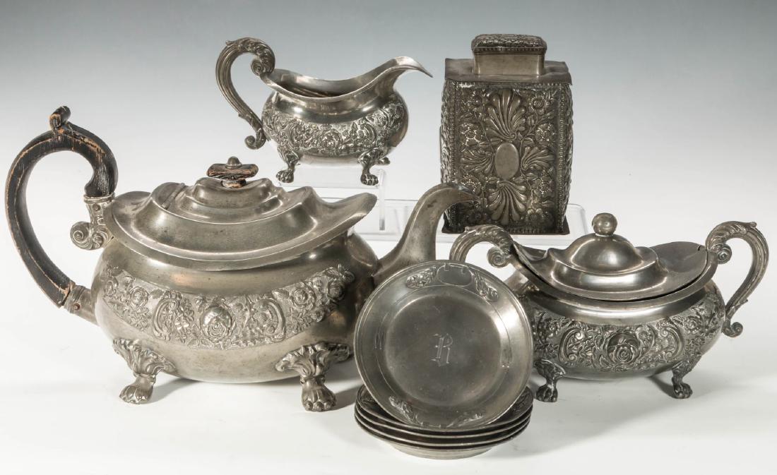 A LATE 19TH C. REPOUSSÉ PEWTER TEA SET: A three-piece George IV pewter tea set, plus tea caddy and five pewter cup plates with monogram. Largest measures 7.25 x 12.5 inches.