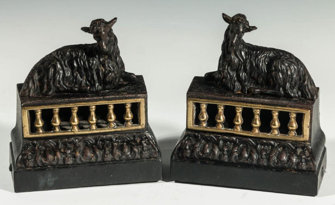 PAIR EARLY 20C. CONTINENTAL FIGURAL IRON BOOKENDS: Ebonized cast iron figural bookends, each featuring a reclining long-haired kid goat on rectangular base with openwork design of a gilt-painted balustrade continuing to an ogee plinth base with cast d