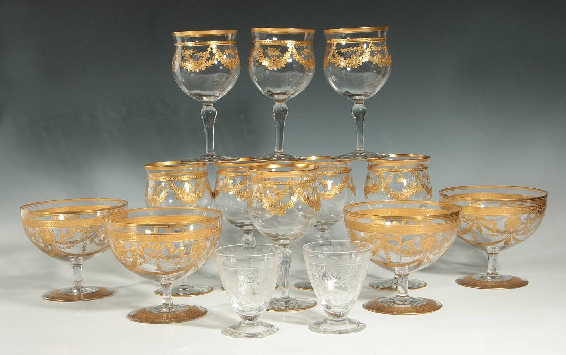 A COLLECTION OF GOLD ENCRUSTED CRYSTAL STEMWARE: Eight hand painted gilt with beading and laurel swags raised on baluster stem and circular foot with gilt trim; four with large bulbous bowl acid etched and gilded lion head masks flanked by ribbons, 