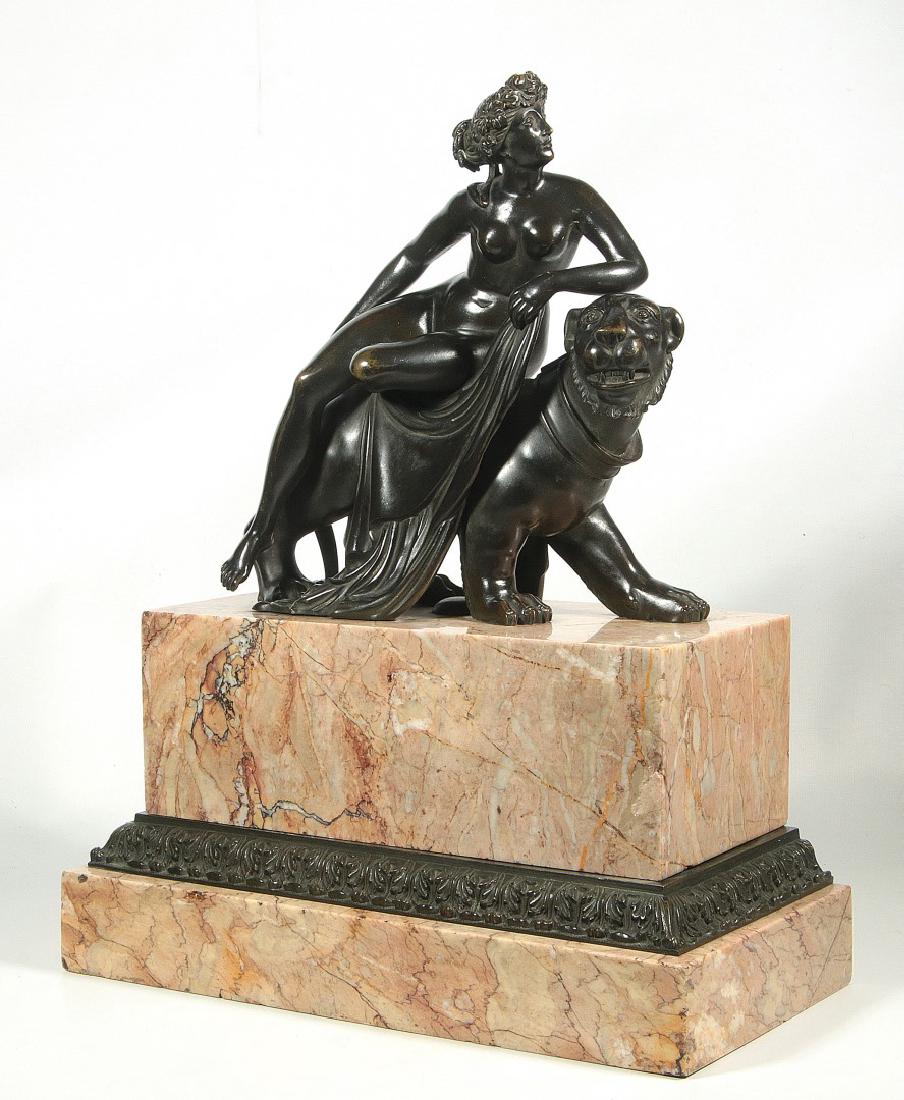 AFTER JOHANN HEINRICH DANNECKER (1758-1841): A late 19th to early 20th century bronze sculpture of Ariadne and the Panther displayed on a rotating marble plinth over a conforming bronze acanthus platform on marble base, after the life-sized vers