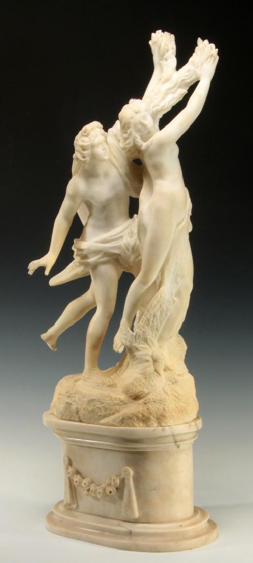 A 19TH C. ALABASTER SCULPTURE OF CLASSICAL FIGURES: Male and female figures flowing in motion on a naturalistic base, robe and laurel wreath between the two; displayed on a conforming oval marble base. Damage and repair as shown. Measures 22.5 x 14 inc