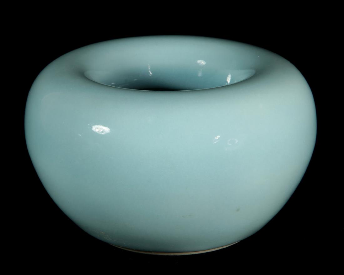 AN ANTIQUE CIRCULAR CHINESE PORCELAIN BRUSH WASHER: With inverted rim, covered in an even thick pale turquoise glaze, the base with an apocryphal mark of the Kangxi emperor (1662-1722). Measures 2.5 x 4.25 inches.