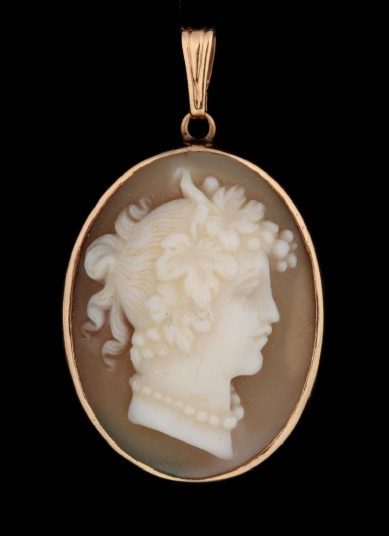 A CARVED SHELL CAMEO BROOCH IN 14K GOLD PENDANT: A good classical bust carved shell brooch in a setting marked 14k, measures 1.125 x .625 inches with the bail, weighs 2.8 grams.