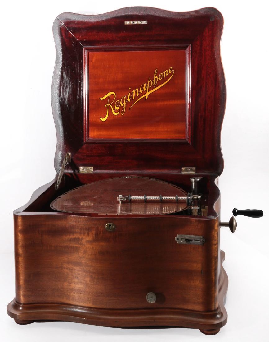 A REGINAPHONE STYLE 155 SERPENTINE CASE MUSIC BOX: A ribbon grain mahogany serpentine case disc music box,double comb movement, plays 15 1/2 inch discs, serial number 1500386, no horn present. Look for a rare matching stand for this machine in this sa