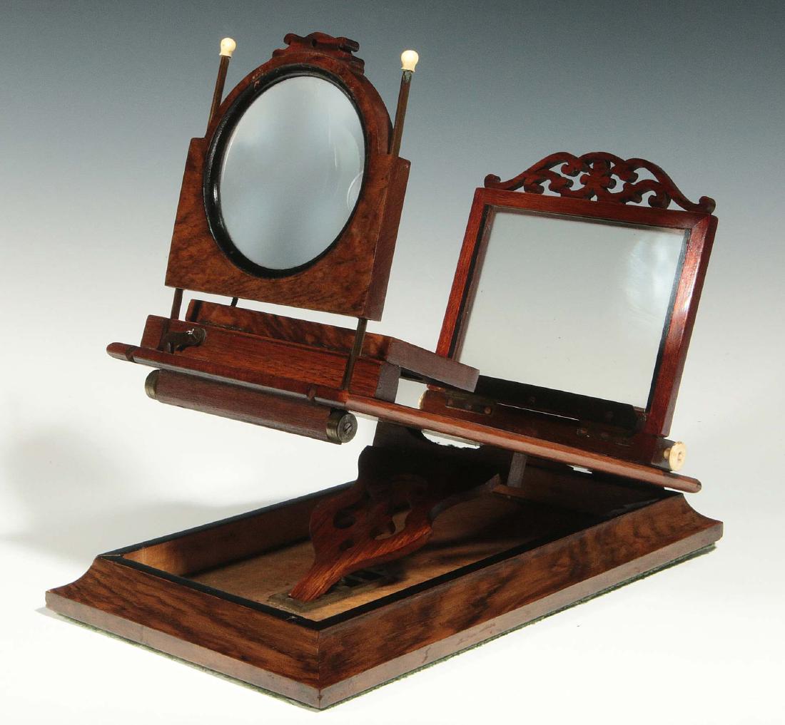 A 19TH C. ROWSELL'S PATENT STEREO GRAPHOSCOPE: A mahogany folding table-top viewer, the graphoscope lens on bone tipped upright rods hinged from underneath to fold-away and allow use of the two lenses for stereo use that are hinged to lie flat on