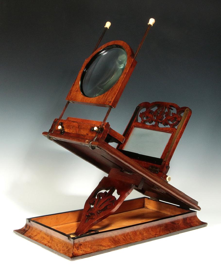 A 19TH C. ROWSELL'S- TYPE STEREO GRAPHOSCOPE: A mahogany folding table-top viewer, the graphoscope lens on bone tipped upright rods hinged from underneath to fold-away and allow use of the two lenses for stereo use that are hinged to lie flat on