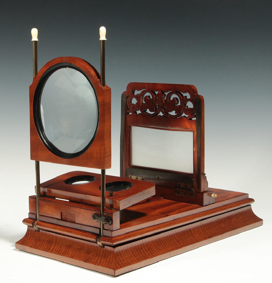 A 19TH CENTURY FOLDING STEREO GRAPHOSCOPE: A table-top device with fold-away steroscope lenses and foldaway graphoscope lens on brass rod uprights with bone tips, scroll-cut card stand with ground glass light diffuser, missing adjustable suppo