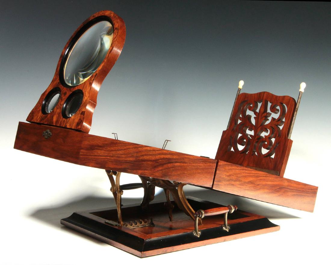AN 1875 DATED FOLDING STEREO GRAPHOSCOPE: A fine rosewood table-top model with single panel magnifying lens and stereo lenses, ornate ormolu scrollwork support, scroll cut easel on brass rods with bone finials, a plaque on the base reads, 'Gr