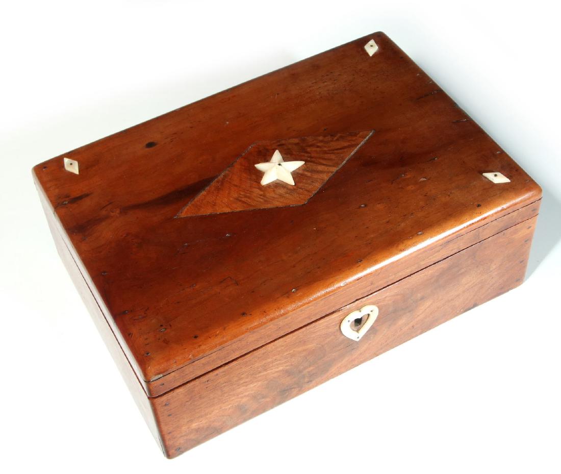 A 19TH C. SAILOR-MADE BOX WITH MARINE IVORY DECORATION: A sewing or ditty box constructed with pine wood bottom boards, mahogany sides and dividers, the top of the hinged lid is an unknown wood - perhaps a tropical species, the lid decorated with an inlaid