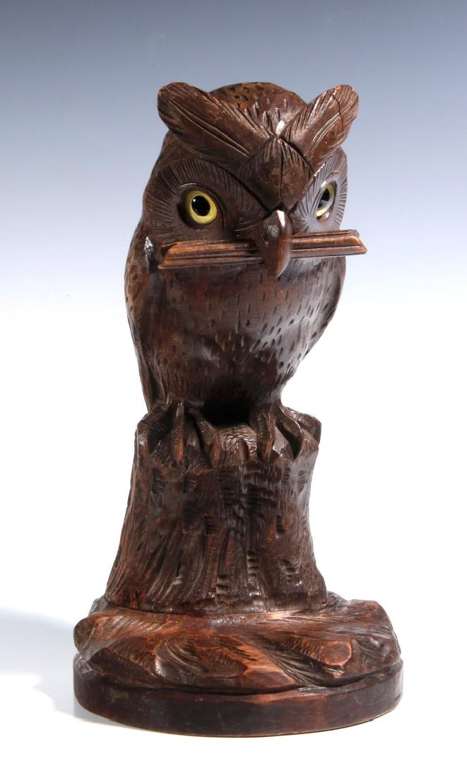 A BLACK FOREST CARVED WOOD OWL FORM WATCH HANGER: An early 20th century carved wood figural watch stand with inlaid glass eyes. Measures 12 x 6 inches. We happily provide seamless in-house packing and shipping services on nearly everything we sell.