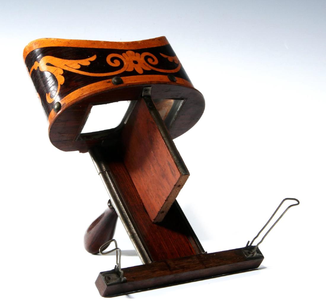 A 19TH CENTURY HAND-HELD STEREOSCOPE: With rosewood marquetry shade, square oculars, rosewood frame, adjustable handle marked 'J.A. Co., patent Nov 12, 18??' Measures 8.75 x 5 inches. We happily provide seamless in-house packing and shipp