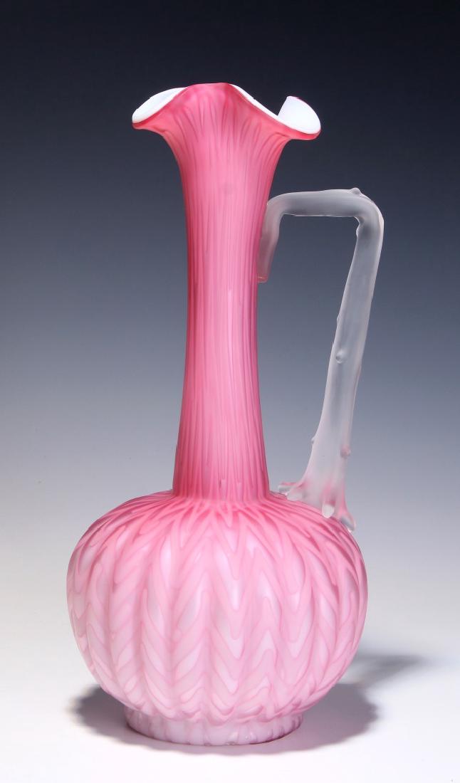A TALL 19TH C. CRANBERRY SATIN MOTHER OF PEARL EWER: A cranberry satin glass ewer cased in white with slender neck, bulbous melon rib base and herringbone pattern internal decoration, applied handle. Measures 12 x 5 inches. We happily provide seamless i