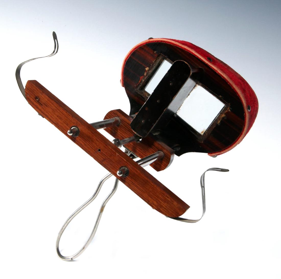 AN UNUSUAL 19TH CENTURY HAND-HELD STEREOSCOPE: With a cardboard shade covered in red velvet, square oculars, faux wood grain, polished nickel slide, handle and mounts. Measures 9 x 8.5 inches. We happily provide seamless in-house packing and shipp