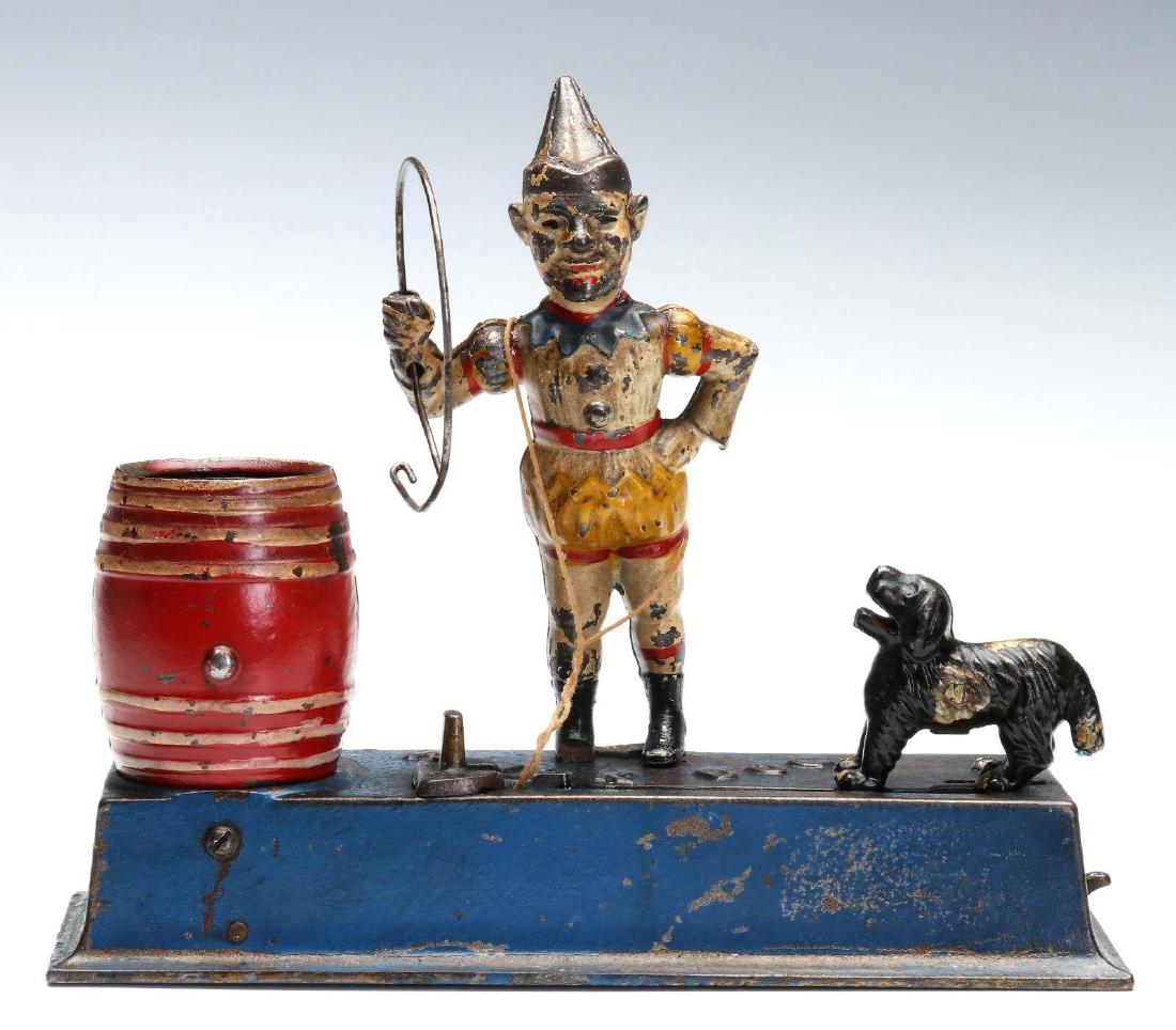 HUBLEY TRICK DOG MECHANICAL BANK: Place a coin in the dogs mouth, slide the lever and the dog jumps through the hoop and deposits the coin in the bank. Marked 'Trick Dog' on the top. We happily provide seamless in-house packing and sh
