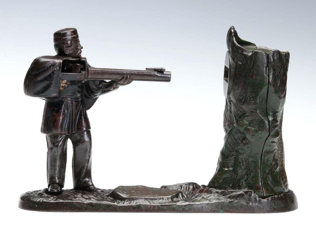 J & E STEVENS CREEDMOOR MECHANICAL BANK: Cock gun and place coin on barrel and insert cap in holder. Press foot lever and soldier fires coin into tree trunk. No makers marks noted. We happily provide seamless in-house packing and shipping se