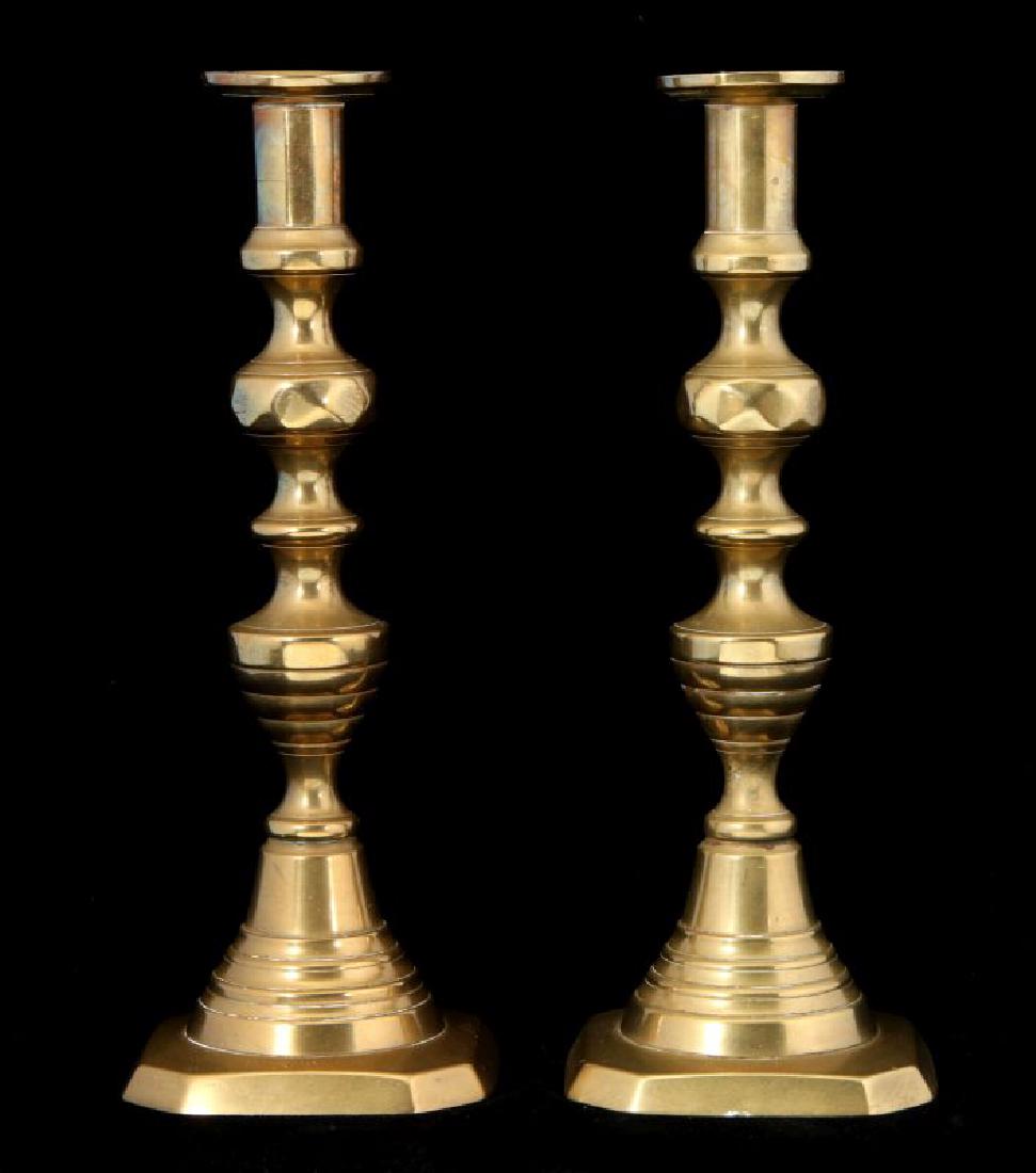 A PAIR 19TH C. BEEHIVE PATTERN CANDLE STICKS: Each with a circular ring lozenge knob above a turned and tapering reeded stem, surmounted by a cylindrical nozzle and circular dish form bobeche, raised on a stepped base above a square foot with cha