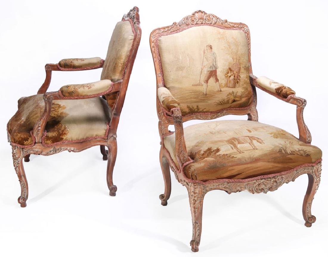 A PAIR 19TH C. LOUIS XV-STYLE FAUTEUILS EN CABRIOLE: Each having a carved and white washed shaped rectangular back with arched crest centering a stylized shell flanked by tapering floral vine above padded back issuing padded scrolling arms on acanthus a