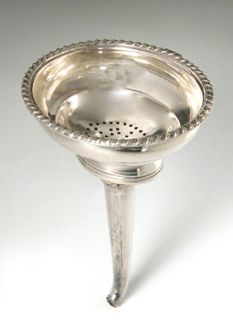 A GEORGE III SHEFFIELD PLATE WINE FUNNEL C. 1800: George III Old Sheffield Plate Wine Funnel of traditional ovoid form, with gadrooned rim and smooth curving spout, together with a conforming pierced liner. Measures 5.5 x 3.5 inches. We happily provi