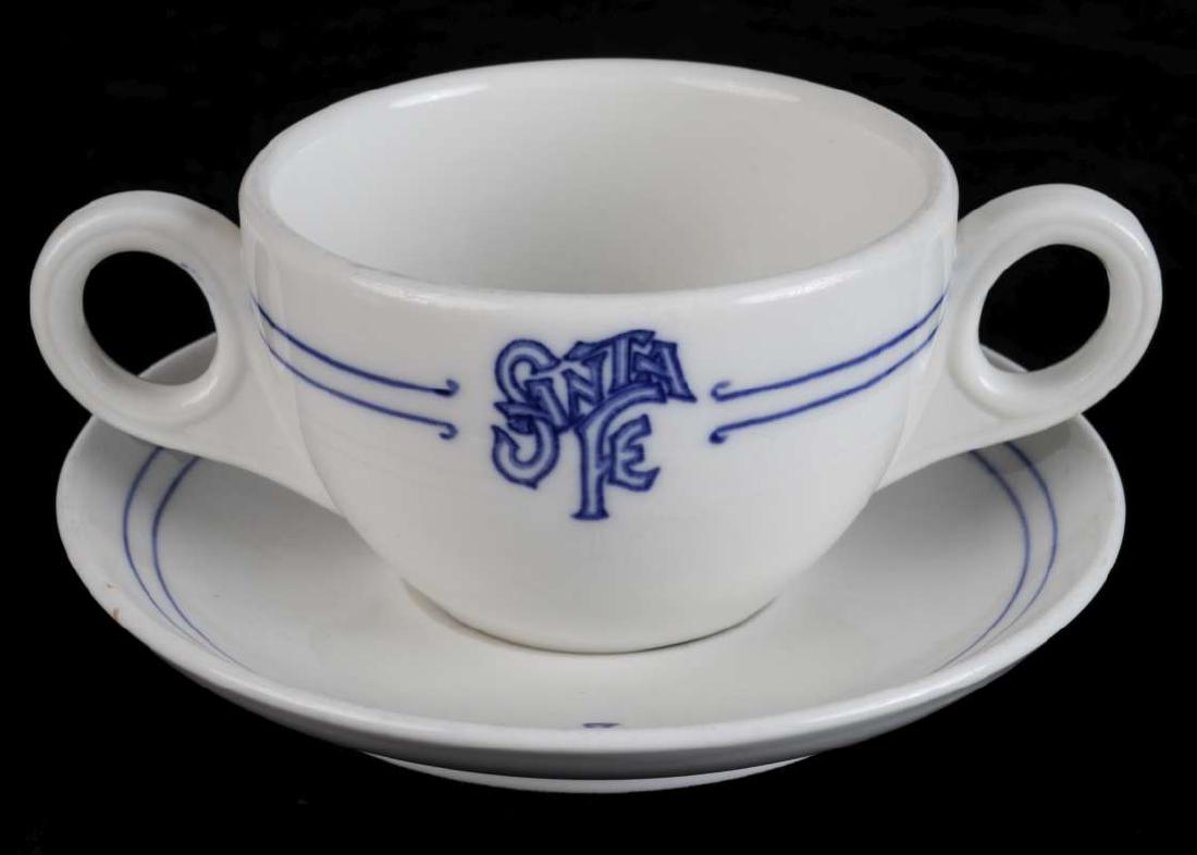 AT&SF BLEEDING BLUE BULLION CUP AND SAUCER: A nice bullion cup and matching saucer, both maker marked Lamberton China, Albert Pick & Co. in blue to their bases. Cup measures 2.5 x 6 inches, saucer 5.75 inches. We happily provide seamless in-hou