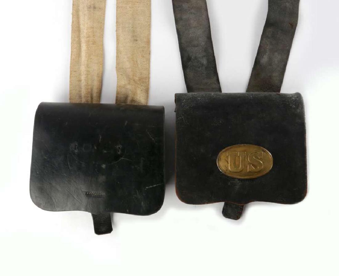 TWO CIVIL WAR AMMUNITION POUCHES: Two black leather ammo pouches, one with US plate, other without. Example with the plate includes two metal lined pockets, securing straps, and leather shoulder strap with brass eagle roundel. Other w