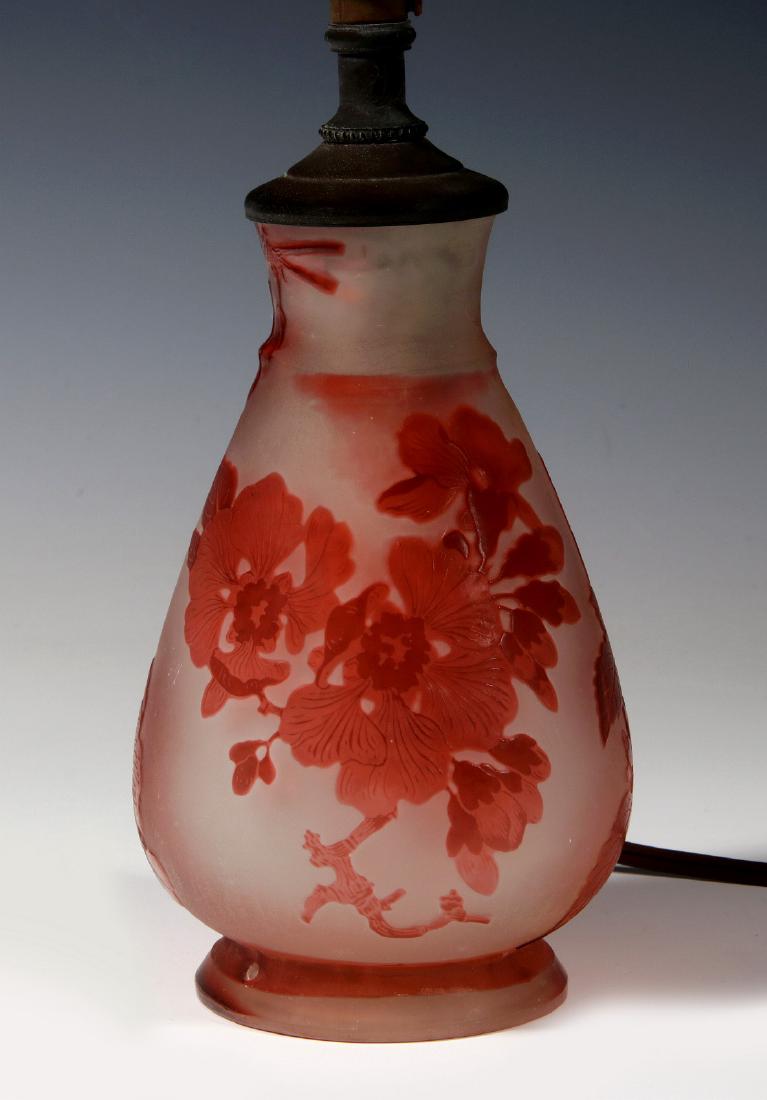 A SIGNED GALLE FRENCH CAMEO LAMP: A small lamp base decorated with acid-etched red flowers, leaves and stems on a white satin ground, signed in cameo near the base. Measures 6 x 3.5 inches, plus socket fitting. We happily provide seam