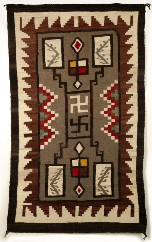 A WESTERN RESERVATION STORM PATTERN NAVAJO RUG: Circa late 20th century, design of two central whirling log devices inside a rectangle with zigzag lines to each of the four corners and four corner squares with interior lightning bolt, a colorful pe