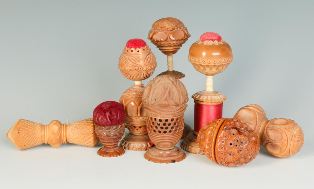 COLLECTION OF VEGETABLE IVORY SEWING ACCOUTREMENTS: A collection of pin cushions, thimble holders, needle cases, etc, all carved from the South American tagua nut, referred to as vegetable ivory. Sizes range from 1.75 to 4.5 inches We happily provide s