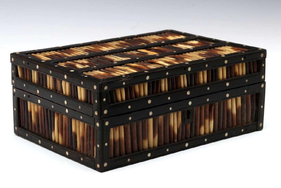 AN ANGLO-INDIAN INLAID PORCUPINE QUILL TRINKET BOX: The mahogany case overlaid with a frame of ebony woods set with porcupine quills in panels divided by wood lattice inlaid with bone, additional inlaid decoration inside the lid. Measures 3.25 x 8 x 5.