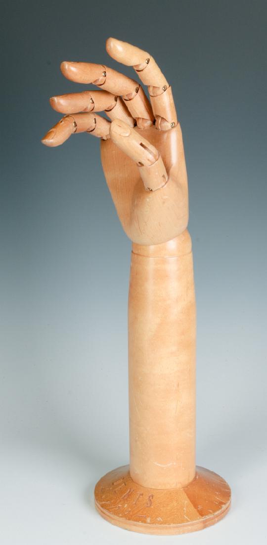 A DENTS ARTICULATED GLOVE HAND MANNEQUIN: A carved maple model of a hand with articulated fingers. Measures 17 x 5 inches. We happily provide seamless in-house packing and shipping services on nearly everything we sell.