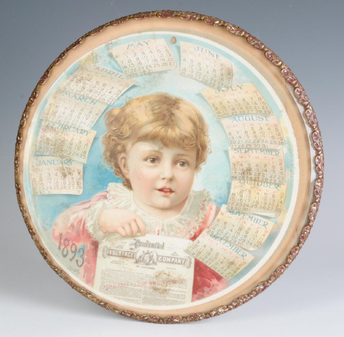 AN 1893 CHROMOLITHOGRAPH CALENDAR BEHIND GLASS: Displayed in an ormolu frame plateau with three ball feet. Measures 10 inches in diameter. We happily provide seamless in-house packing and shipping services on nearly everything we sell.