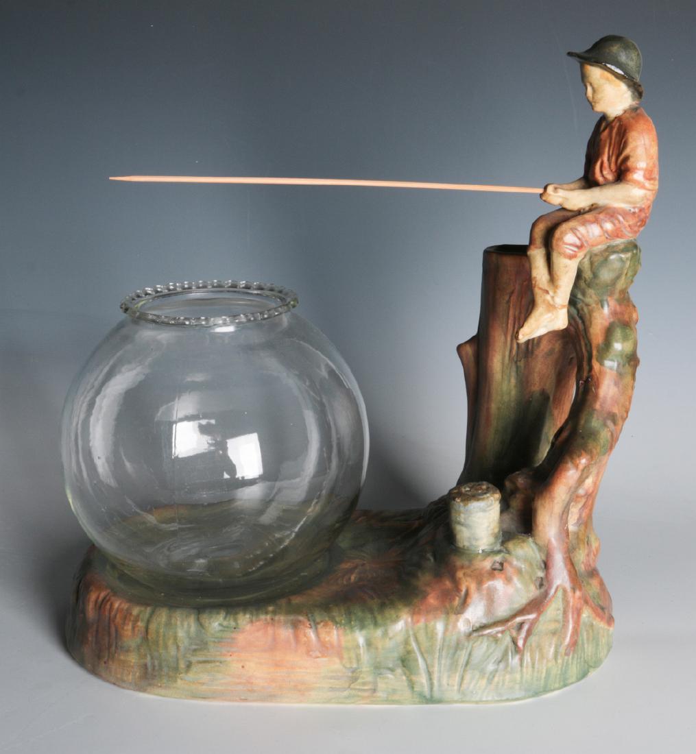 WELLER WOODCRAFT MUSKOTA FISHER BOY AND BASE: A Weller art pottery Muskota Fisher Boy on fish bowl base. Includes a glass bowl. Measures 12 x 10.5 inches. We happily provide seamless in-house packing and shipping services on nearly everything we 