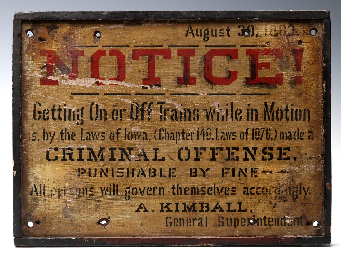 A PAINTED WOOD IOWA RAIL YARD SIGN DATED 1883: A notice warning that Getting On or Off Trains While in Motion is, by the laws of Iowa .a Criminal Offense. A man named Abel Kimball served as the Superintendent of the Iowa Division of the Chicago, R