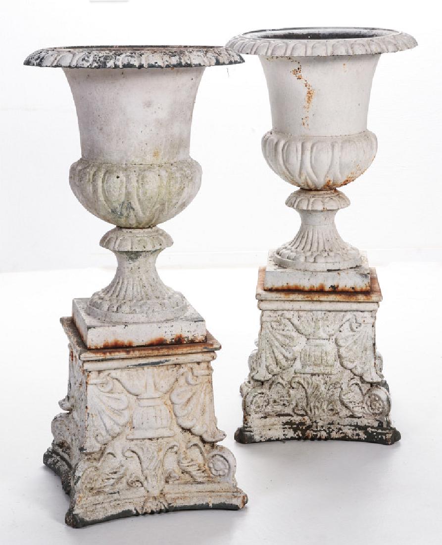 A PAIR OF CAMPAGNA FORM CAST IRON URNS ON PLINTHS (1 of 12)