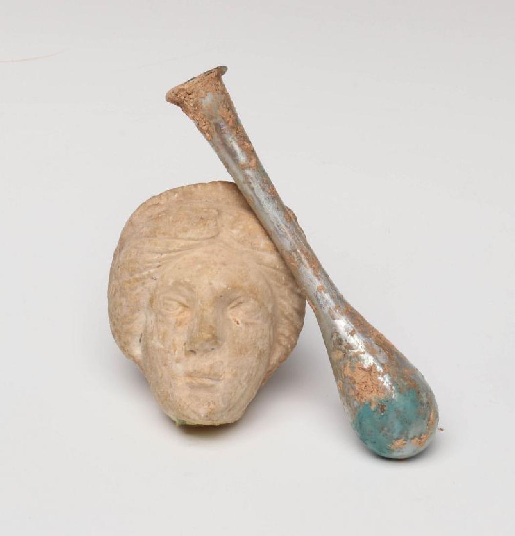 A ROMAN GLASS VASE WITH CARVED STONE HEAD (1 of 9)