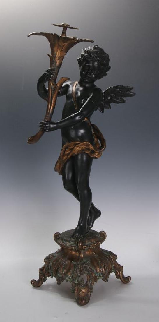AN ANTIQUE 24-INCH PATINATED SPELTER CUPID FIGURE: The standing figure of cupid, holding a figural gilded torch, the standing figure in black with gilded sash and robe, rococo style footed base. Measures 25 x 7.5 inches. We happily provide seamless in