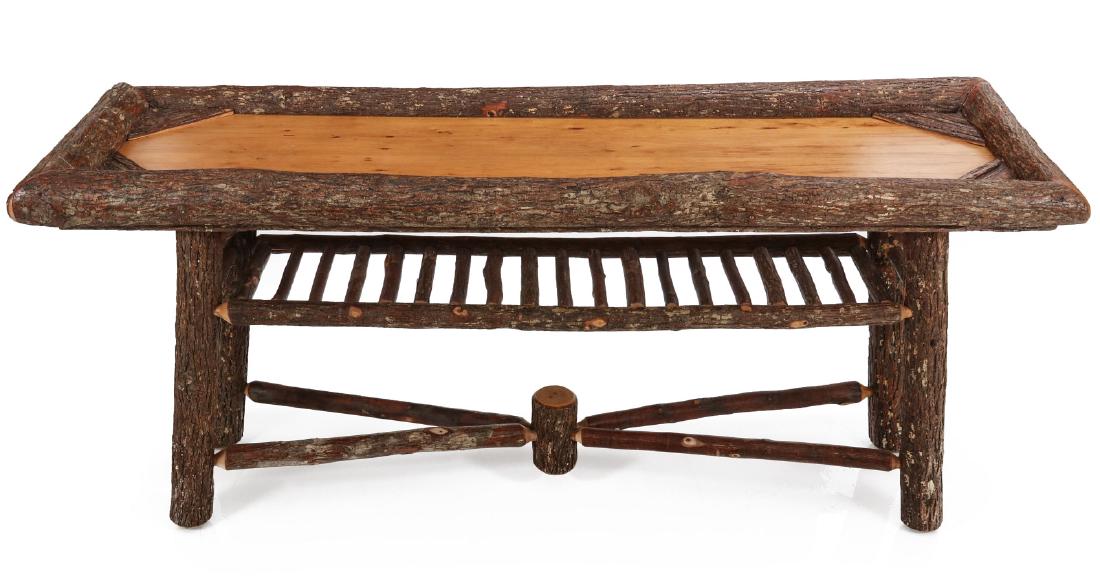 A LATE 20TH CENTURY LONG RUSTIC HICKORY LOG TABLE: Made by the highly desirable Old Hickory Furniture Company, this late 20th century example has a rectangular plank board top that is mitered framed by thick unfinished hickory logs, the four conformin