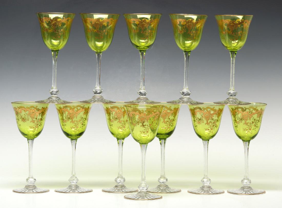 TWELVE FINE FRENCH ENGRAVED, GILDED WINE GOBLETS: A matching set of twelve, the green bowl with needle etched rococo designs with floral sprays, the zipper cut stem with faceted knob just above the circular foot with cut ray design underside, circa e