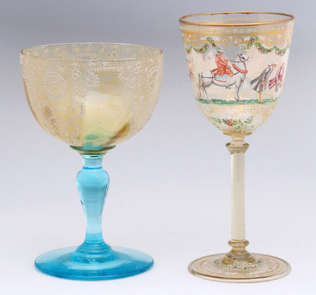 TWO INTERESTING ENAMELED ART GLASS WINE GOBLETS: A hand enameled stem with colonial subjects, manner of Salviati, plus an example with hand painted enamel lace on amber glass and an electric blue stem with enameled initials under the foot. Measures 