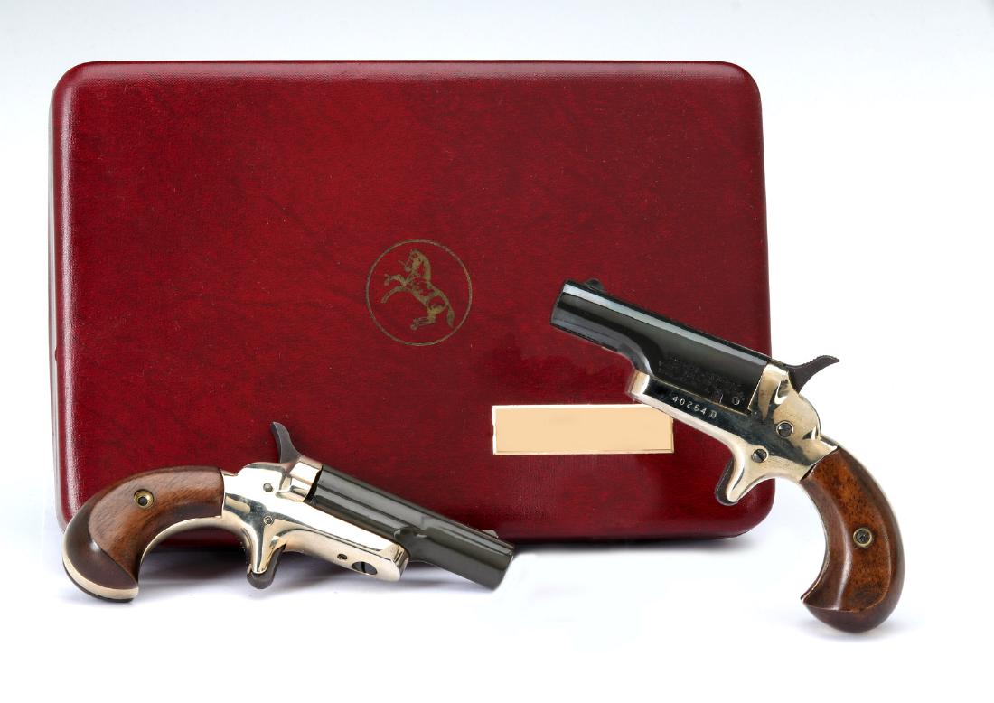 COLT DERRINGER CASED SET .22 SHORT: Colt .22 NMN (serial #:40263Dand40264D) Consecutively numbered pair of single shot Derringers in a velveteen and satin lined red case with the rampant Colt on the lid. Measures 2.5 inch barrel, 5 inch