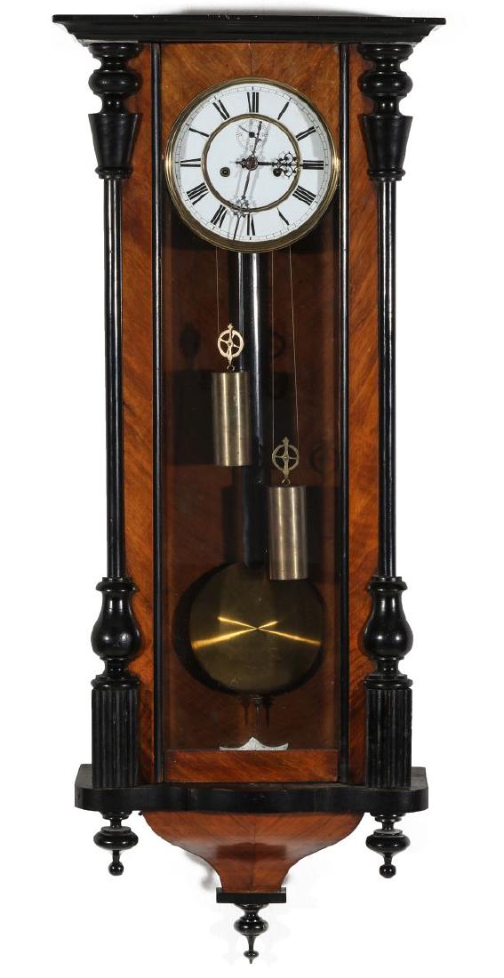 A 19TH CENTURY TWO WEIGHT VIENNA REGULATOR: The case with ebonized turned wood half-columns and drop finials, enameled dial with trim ring and Roman numerals, seconds bit, enamel beat plate, filigree hands, two weights, two winding apertures, b