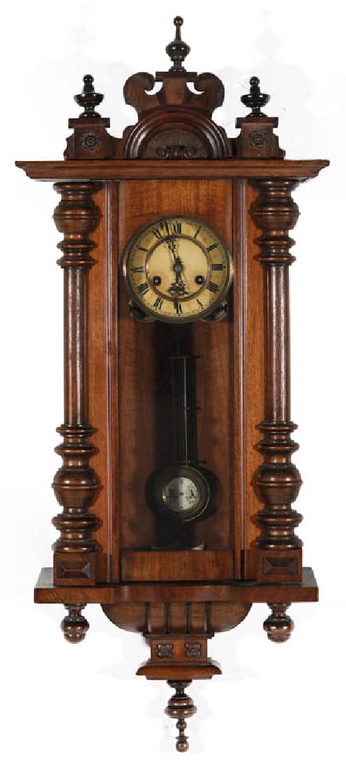 A SCHLENKER & KIENZLE GERMAN REGULATOR CLOCK: A German wall hanging clock with turned wood finials and half-columns, Roman numeral dial, enameled RA pendulum, signed with a logo on the movement and patent number 147023, a nice model. Measures 39 