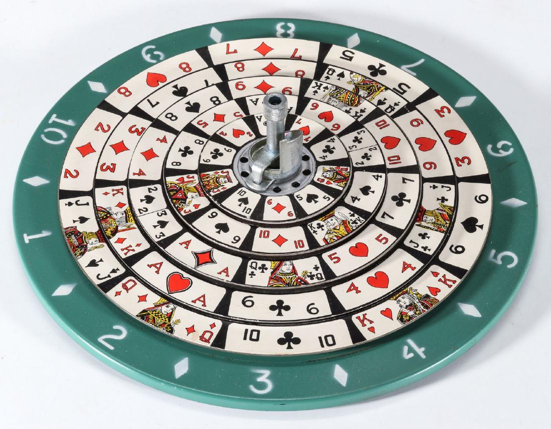 VINTAGE SPIN / STOP PLAYING CARD ROULETTE GAME: The multiple layers of flat circular discs punched with interior holes and stacked on a central spindle, the top central knob operates downward facing spindles that alternately spin and stop the discs