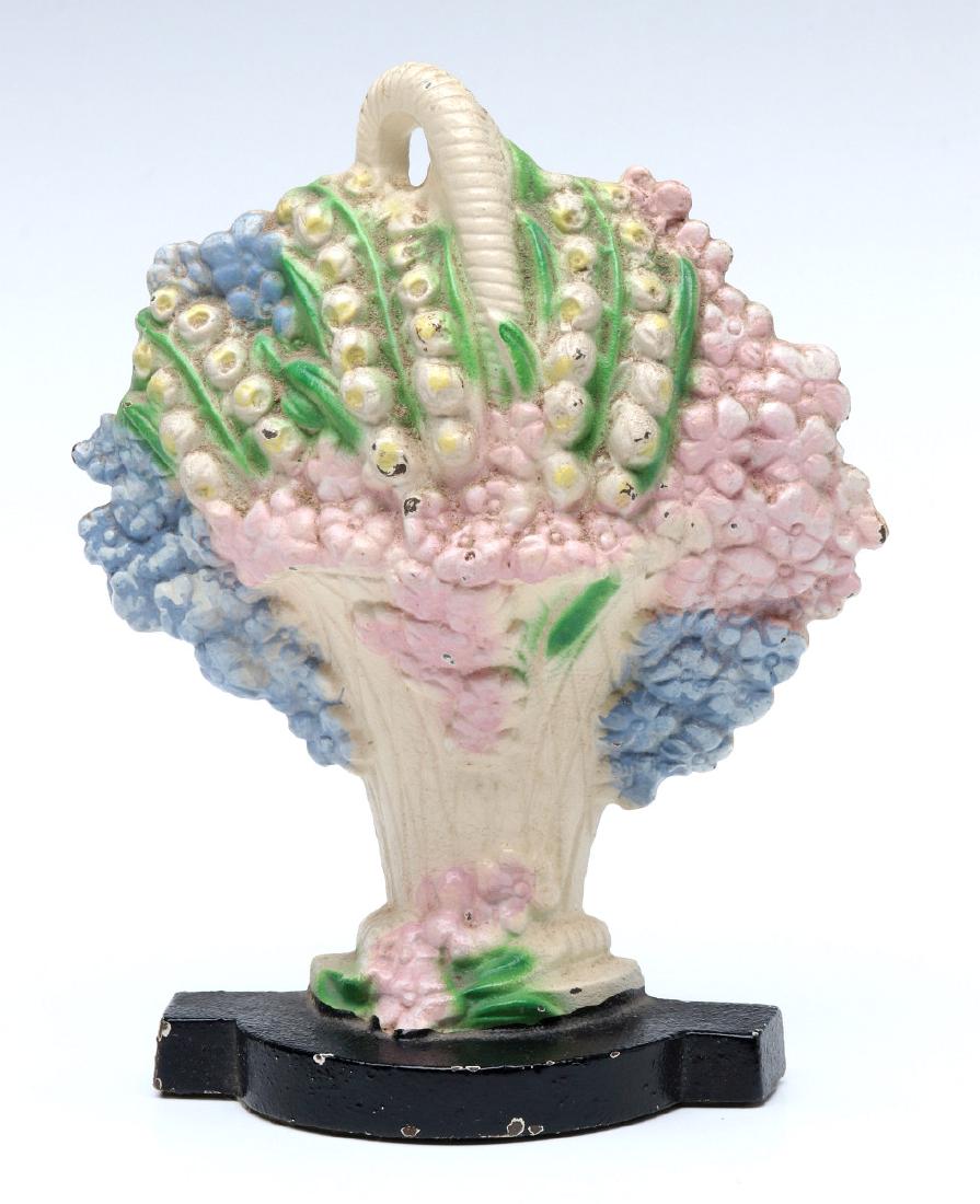 A HUBLEY PHLOX AND LILIES DOORSTOP No. 473: A single-sided polychrome doorstop, Hubley Phlox and Lily of the Valley #473, marked on the back. Measures 5.75 x 4.25 x 1.5 inches. We happily provide seamless in-house packing and shipping services 