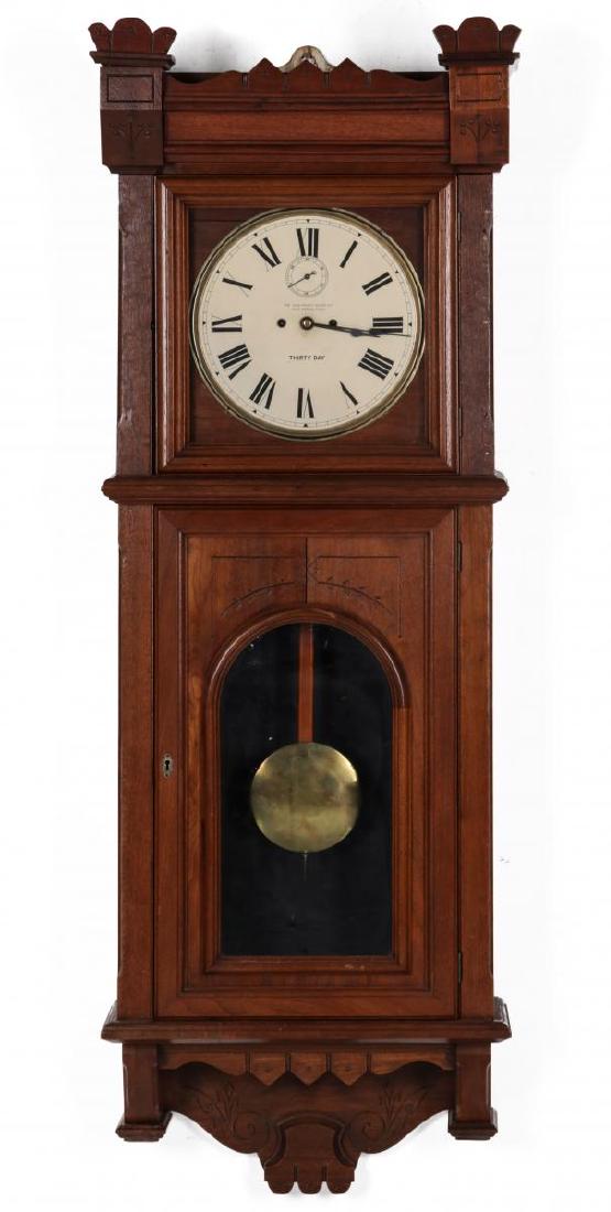 WALL CLOCK WITH NEW HAVEN MOVEMENT AND DIAL: Circa 1889 movement, modern dial with Roman numerals and a seconds bit, two winding apertures, brass pendulum, signed on the dial and movement, patent dated 1889. Measures 64 x 22 x 10 inches. We happ