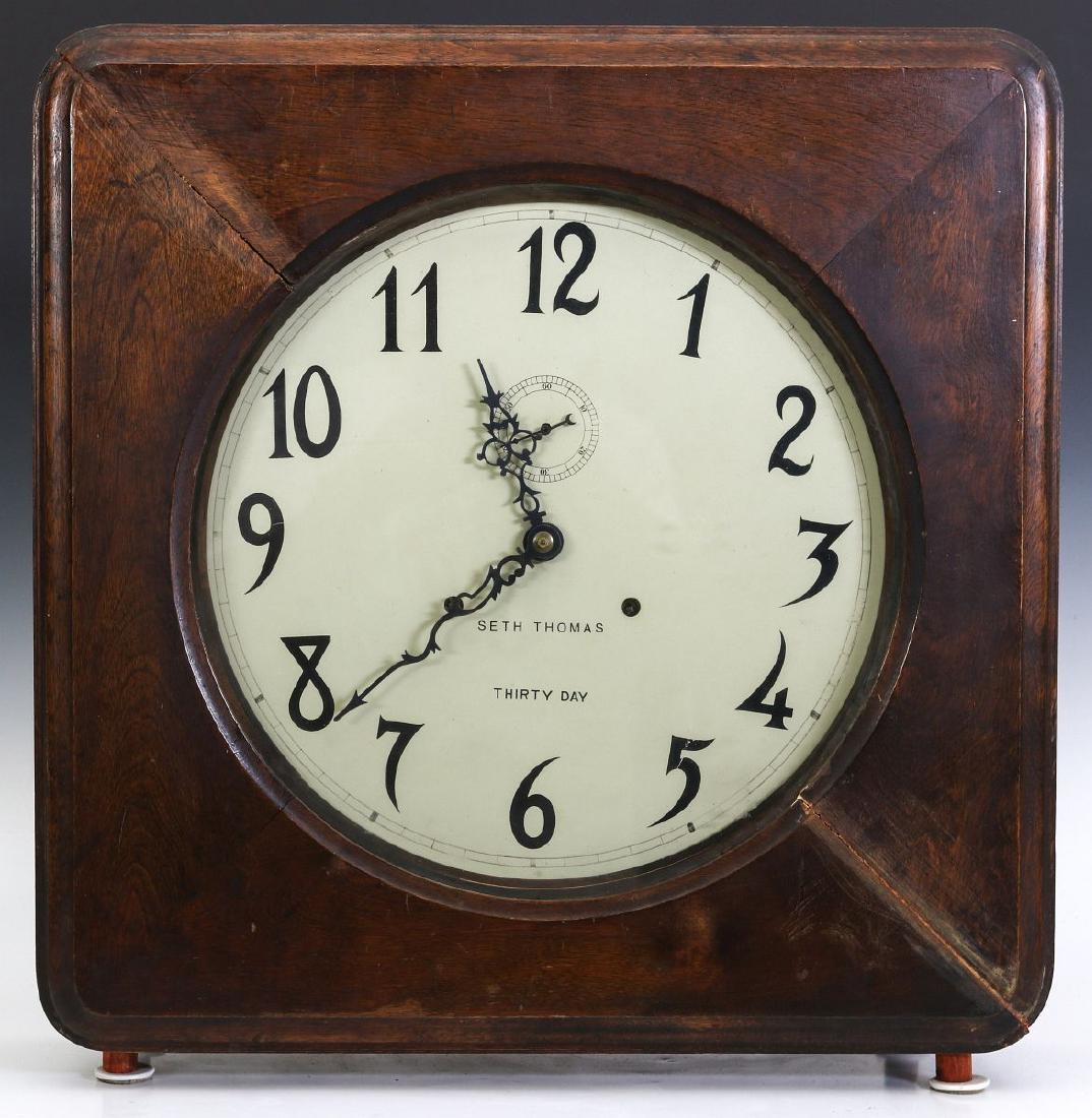 A SETH THOMAS OFFICE MODEL GALLERY CLOCK: The maple case with hinged front door, replacement dial. Measures 21 x 21 x 7 inches not including the peg feet. We happily provide seamless in-house packing and shipping services on nearly everything